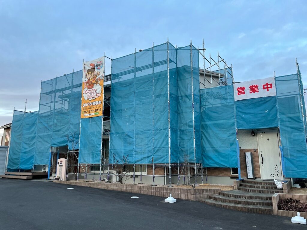 足場組立<br />
（塗料が飛散しないようにメッシュシートもしっかりとはります）