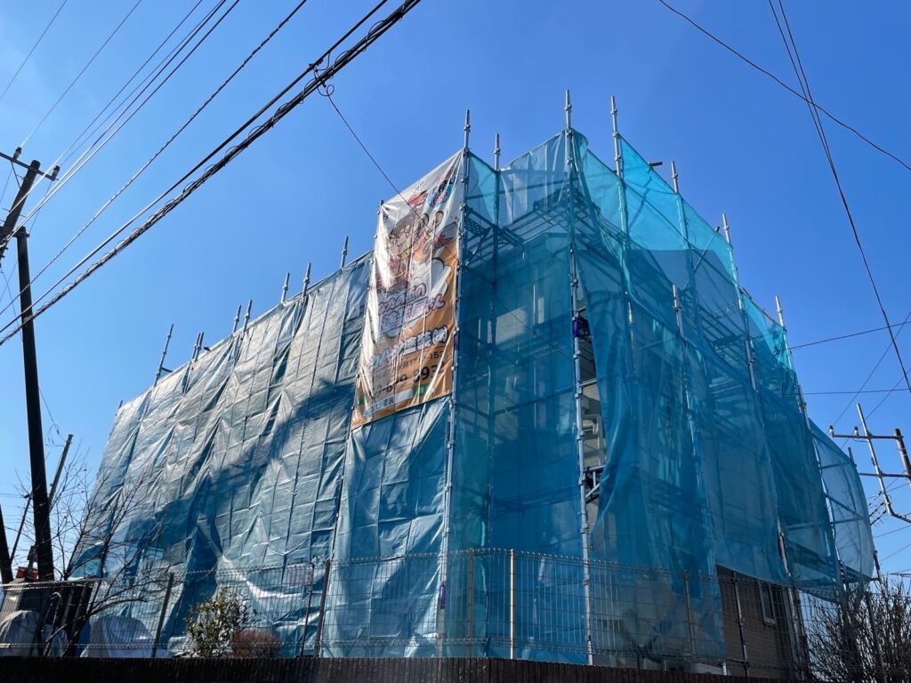 足場組立<br />
（塗料が飛散しないようにメッシュシートもしっかりとはります）