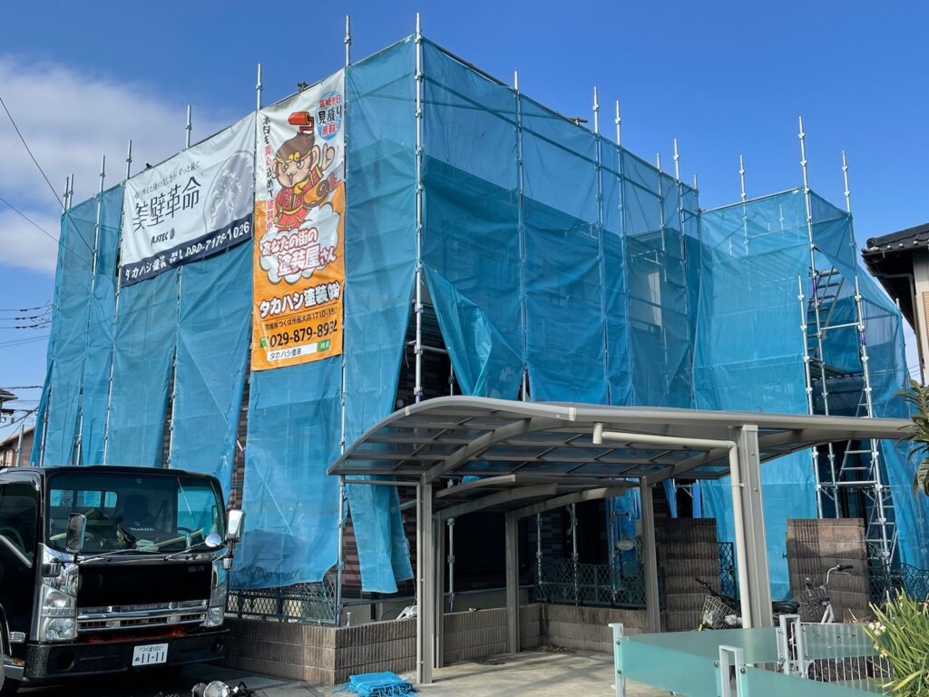 足場組立<br />
（塗料が飛散しないようにメッシュシートもしっかりとはります。）