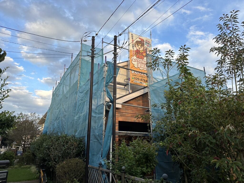 足場組立<br />
(塗料が飛散しないようにメッシュシートをしっかりと貼りました。)