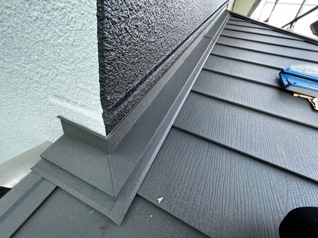 雨押さえ取り付け<br />
（外壁と屋根の取り合い部を雨押さえといいます。雨漏れがしやすい箇所の為、雨仕舞をしっかりと行うことが重要です。<br />
※屋根の下に板金を入れ、雨が中に入らないようにしています。）