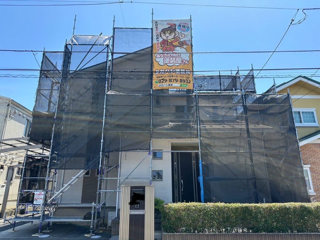 足場組立<br />
（塗料が飛散しないようにメッシュシートをしっかりと貼りました。）