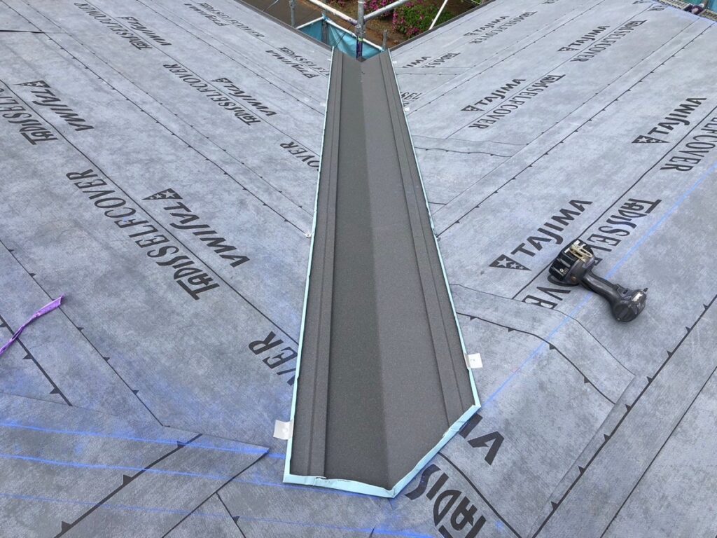 谷板金取り付け<br />
(屋根と屋根が重なり合う部分に取り付ける金物です。)