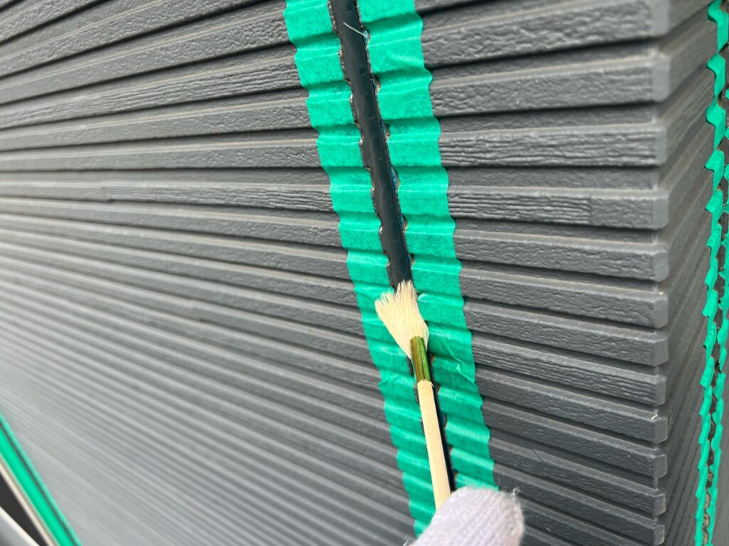 目地コーキング：プライマー塗布<br />
（外壁とコーキングを密着させる為の接着剤です。とても重要な工程です。）