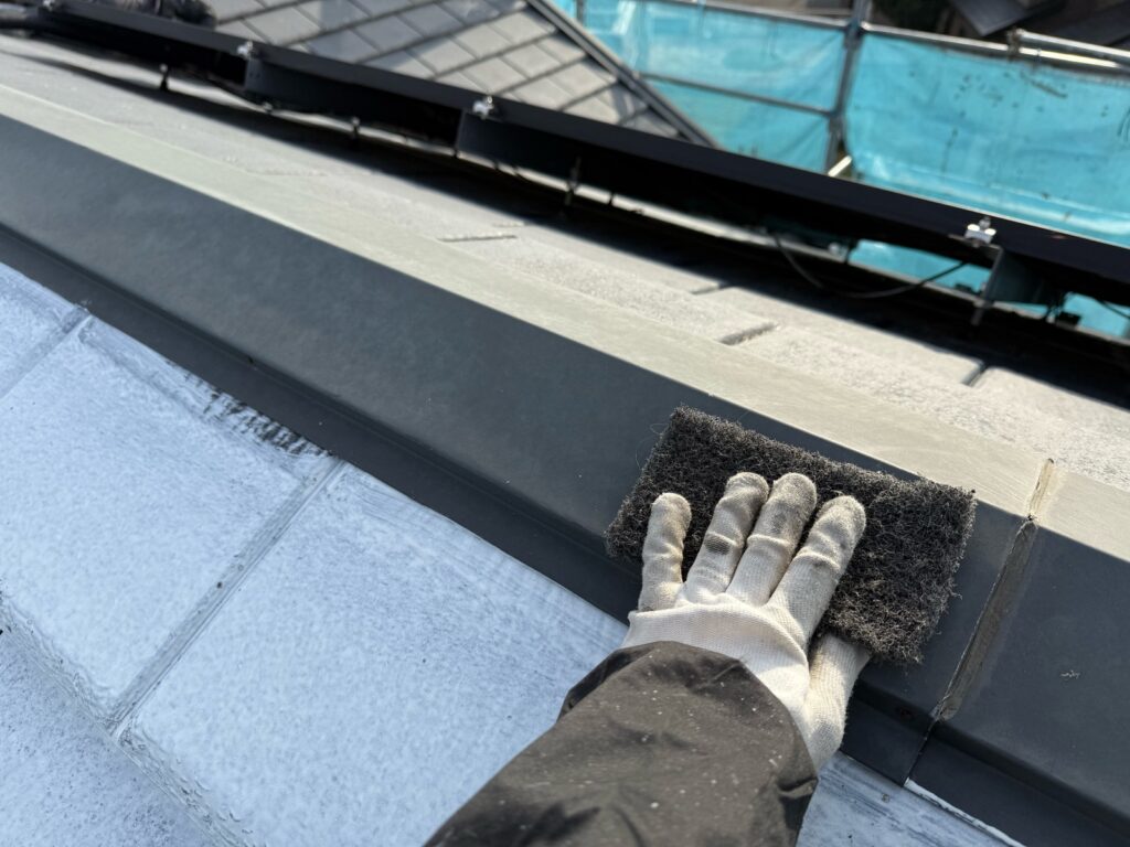 棟板金ケレン<br />
（ケレンとは、塗料との密着を良くするために、専用の道具で細かい傷をつける下地調整です。）