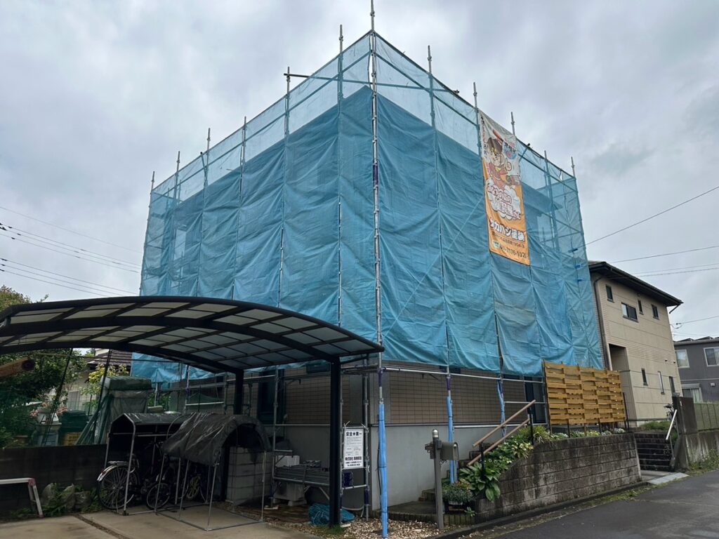 足場組立<br />
（塗料が飛散しないようにメッシュシートをしっかりと貼りました。）
