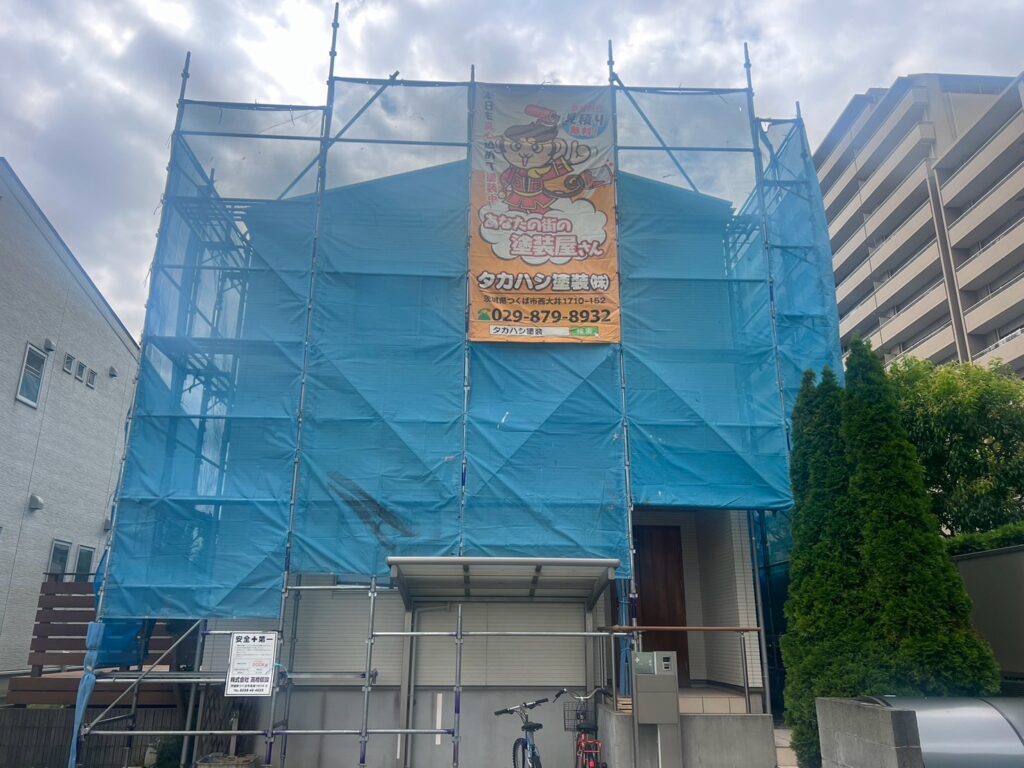 足場組立<br />
（塗料が飛散しないようにメッシュシートをしっかりと貼りました。）