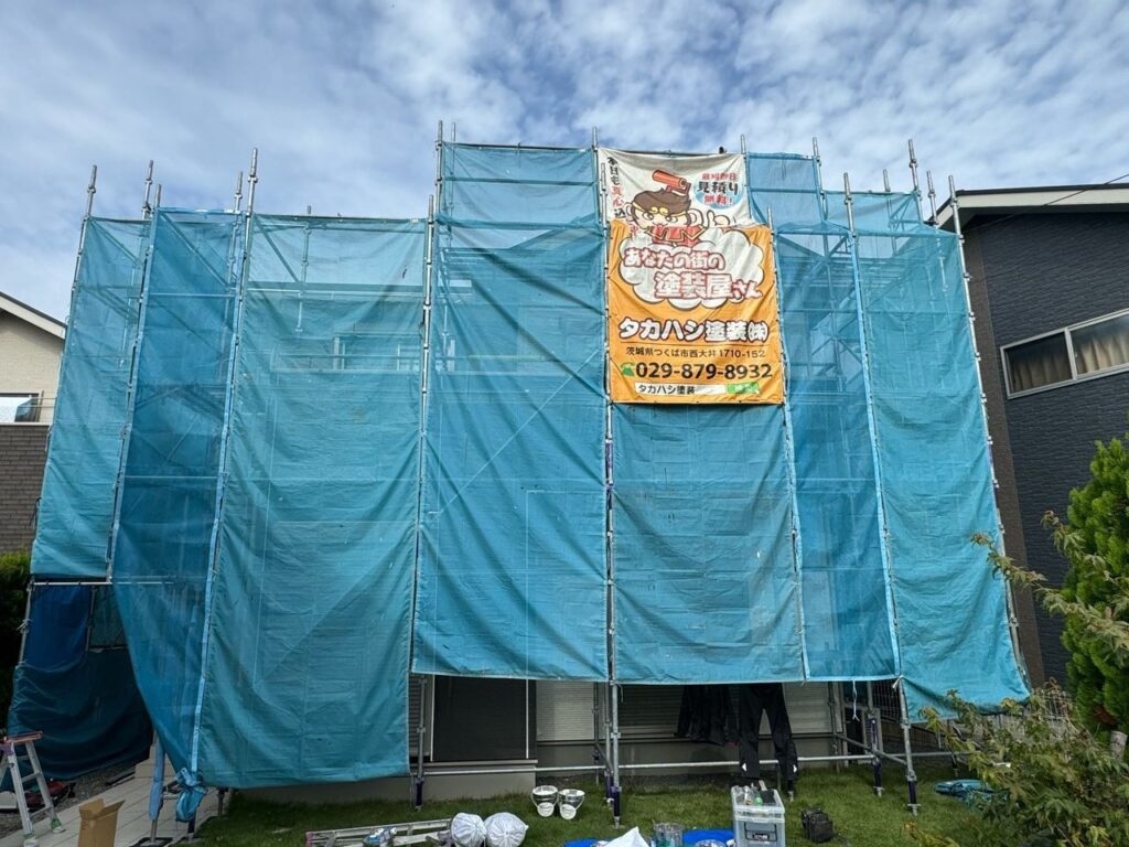 足場組立<br />
（塗料が飛散しないようにメッシュシートをしっかりと貼りました。）