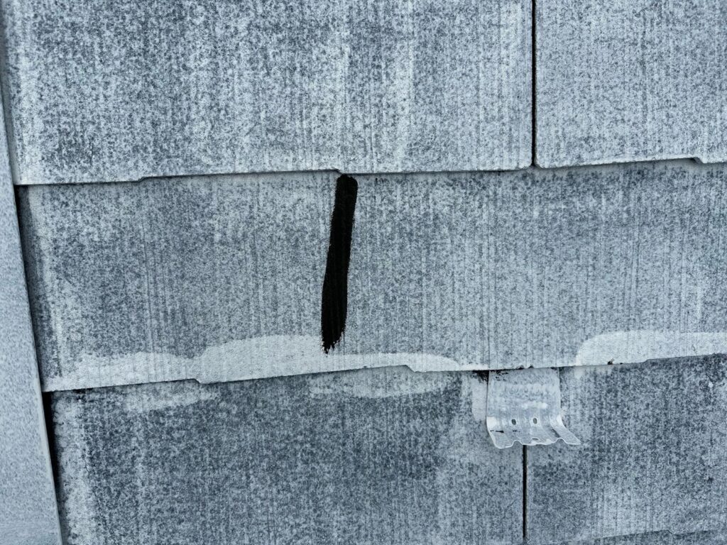 ひび割れ補修<br />
（屋根の仕上げ色に合わせて黒色で補修をしました。）