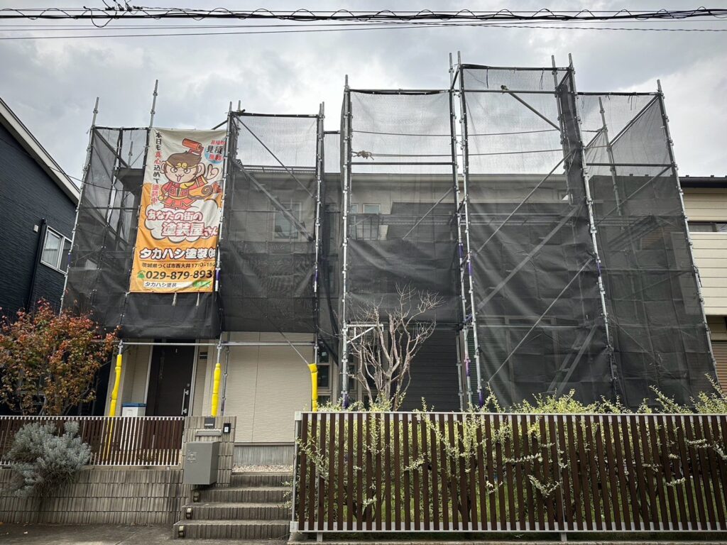 足場組立<br />
（塗料が飛散しないようにメッシュシートをしっかりと貼りました。）