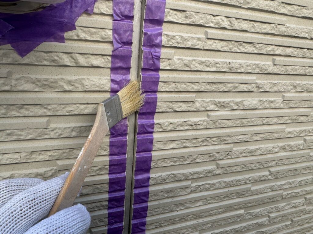 目地コーキング：プライマー塗布<br />
（外壁とコーキングを密着させる為の接着剤です。とても重要な工程です。）