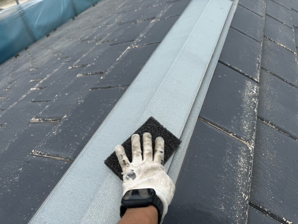 棟板金ケレン<br />
（ケレンとは、塗料との密着を良くするために、専用の道具で細かい傷をつける下地調整です。）