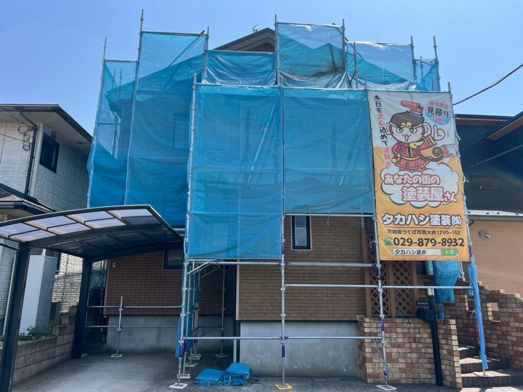 足場組立<br />
（塗料が飛散しないようにメッシュシートをしっかりと貼りました。）