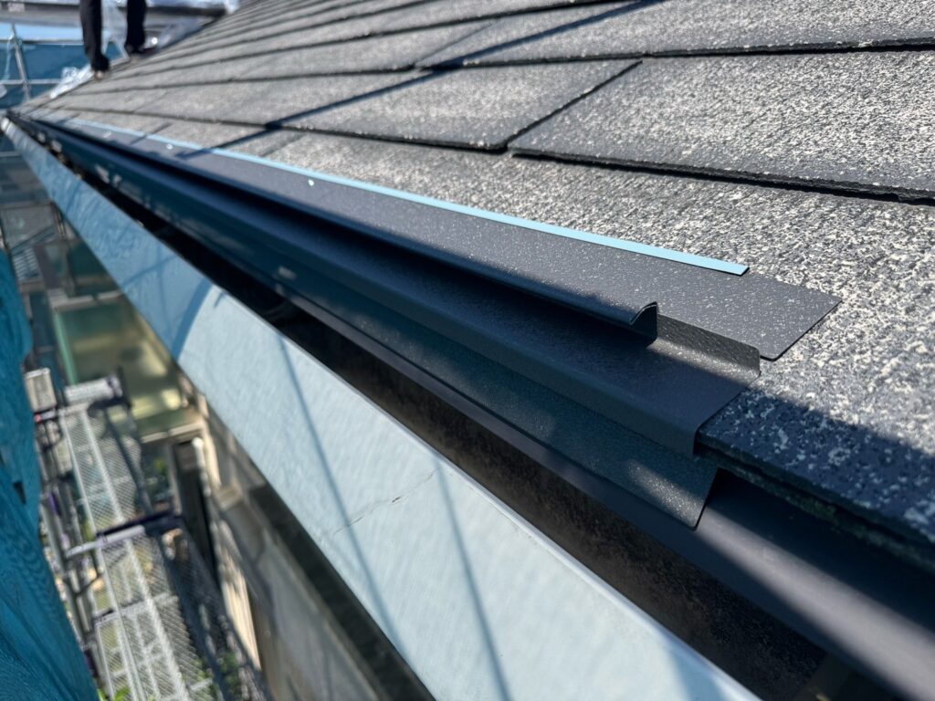 唐草スターター取り付け<br />
（屋根カバー工事の際に一番最初に取り付ける金物です。）<br />
<br />
※既存の雨どいを交換しなくても雨水が雨どいに流れるように、セットバックスターターという唐草を使用しています。通常の唐草でカバー工法を行うと、雨水が雨どいに流れなくなる可能性があるため、こちらを使用します。